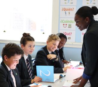 A peer educator helps peer learners with an activity
